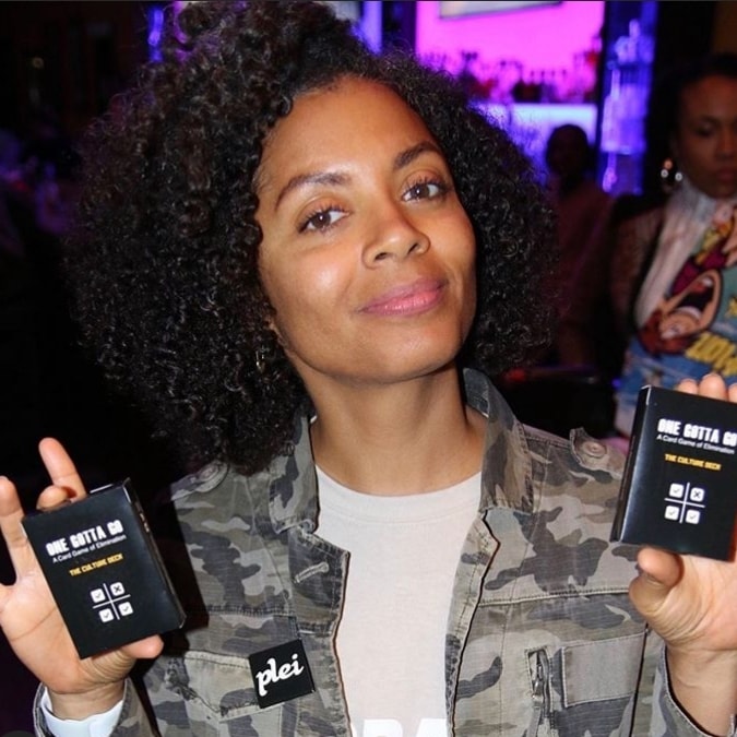 Woman at an event holding two Culture Decks