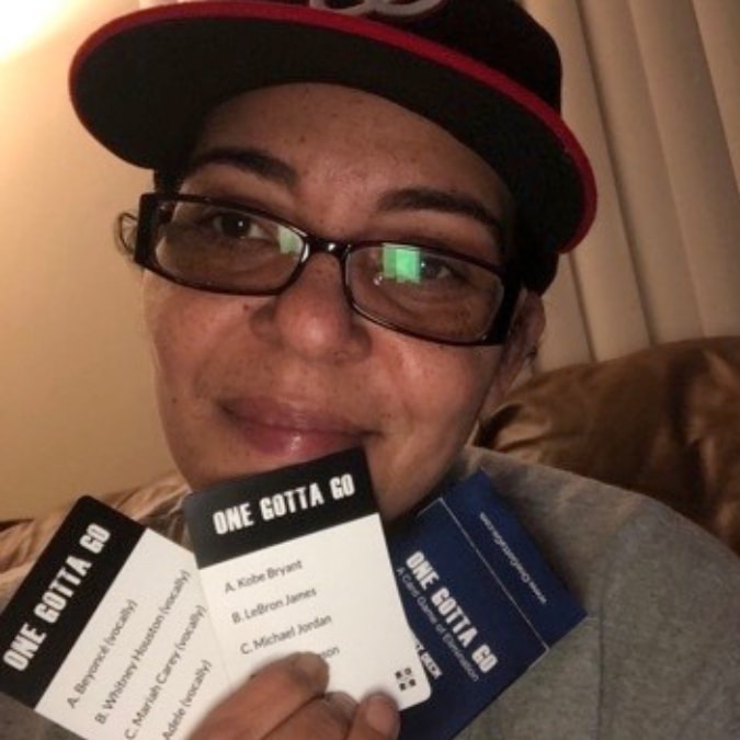Player holding One Gotta Go cards: Beyonce, Whitney Houston, Mariah Carey, Adele